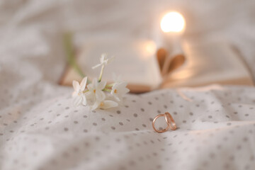 Wedding golden ring and open book with folded sheets in heart shape in bed. Wedding concept, Happy...