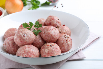 Many fresh raw meatballs on white wooden table, closeup