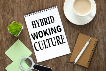 HYBRID WORKING CULTURE open notepad with text near different stationery and stickers. on a wooden background. business concept
