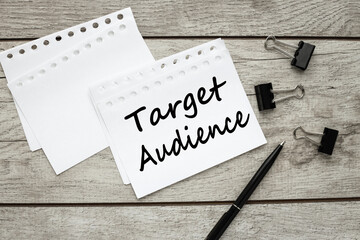 Target Audience. white paper notepad sheets on a wooden table near a pen