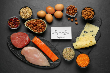 Different fresh products and paper with Arginine chemical formula on black table, flat lay. Sources of essential amino acids