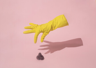 Hygienic glove catches the poo on a pink background. Minimal lay out composition.