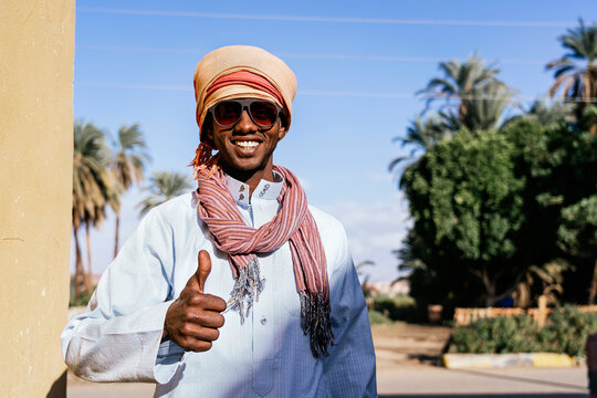 Glad Egyptian man in turban in tropical city