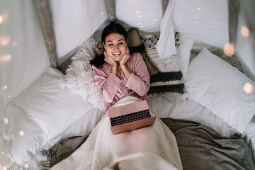 Asian woman using laptop in wigwam tent at home © BullRun