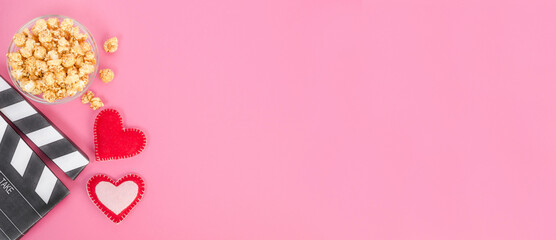 Valentine's Day movie concept. Movie clapperboard with hearts and caramel popcorn with copy space