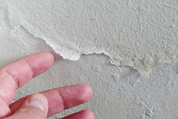 The paint on the wall of a damp house is peeling and blistering, damp wall, moldy house wall,