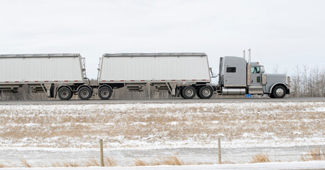 Heavy Cargo on the Road in Winter. A truck hauling freight along a snowy highway. Taken in Alberta, Canada