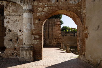 Fototapeta premium selective focus on ancient ruins of the first American hospital, San Nicolás de Bari in Santo Domingo, early 16th century. Arches, columns and walls of red brick and cobblestone