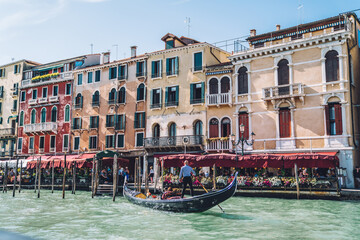 Venice Italy - Grand Canal with gondola taxi and old houses with restaurants along embankment, ancient architecture buildings for exploring during water sightseeing on romantic travel vacations