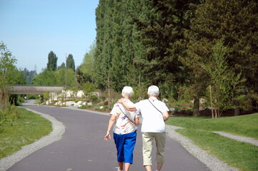 Lesbian female seniors walking on a trail outside.