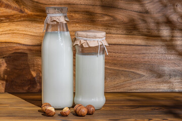 Lactose-free free-dairy macadamia products, mock-up. Bottles with milk, cheese, sour cream, butter on a wooden background. Fresh food