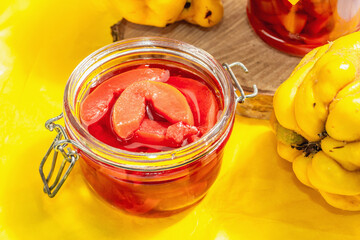 Ripe whole quince and sweet jam from it isolated on white wooden background