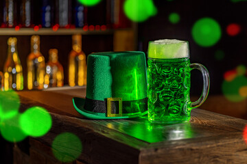 Mugs of green beer, ale on the bar counter. Holiday of Ireland on St. Patrick's Day in irish pub, bar. Festive Leprikon's green hat. National tradition of carnival celebrating March 17