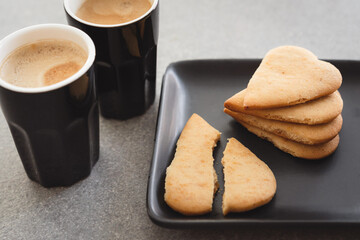 Heart shaped biscuits, butter cookies and coffee. Broken heart – first love or break of relations? Do what you love? Valentine’s Day concept.
