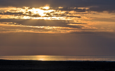 Naklejka na ściany i meble Sunrise on a foggy morning on the Black Sea coast.