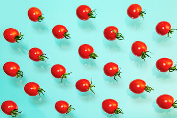 Juicy red cherry tomatoes on a blue background. Pattern.