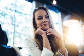 Young content happy woman smiling in cafe