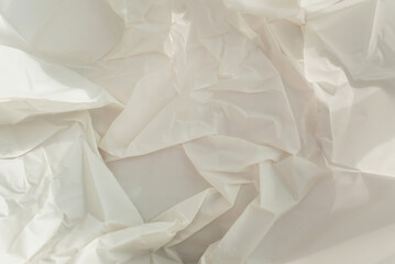 Obraz premium Crumpled craft white paper with hard shadows. Close up background.