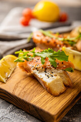 Selection of tasty bruschetta or canapes with salmon.Sandwich with salted salmon, arugula and cream cheese on a wooden board.