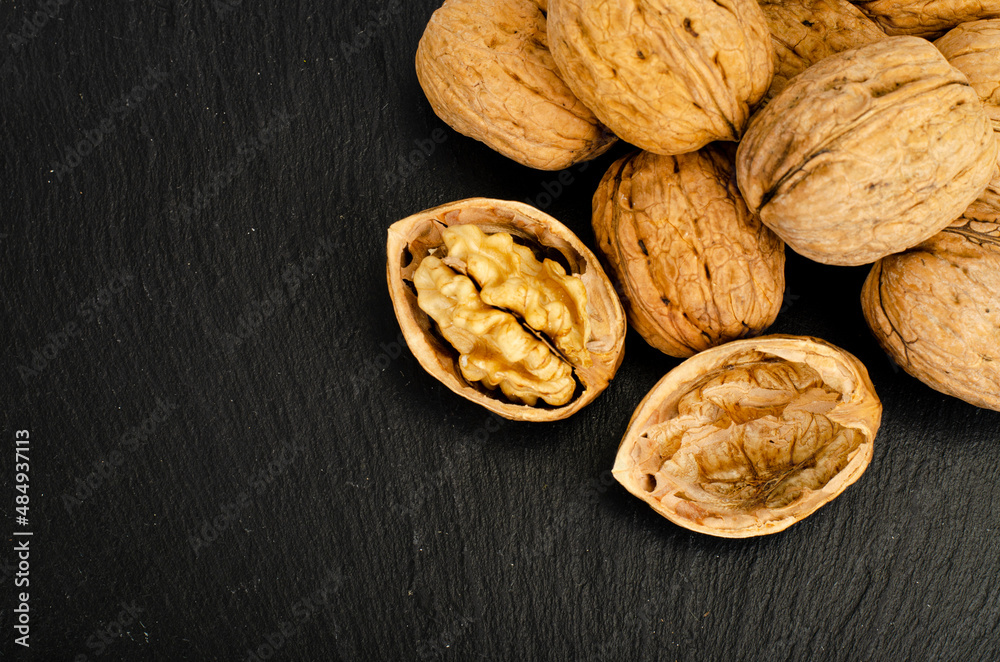 Wall mural ripe walnuts on black background. studio photo