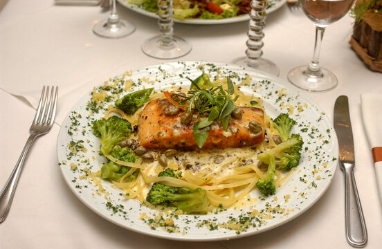 Grilled salmon with linguine, capers and broccoli. Gastronomy.