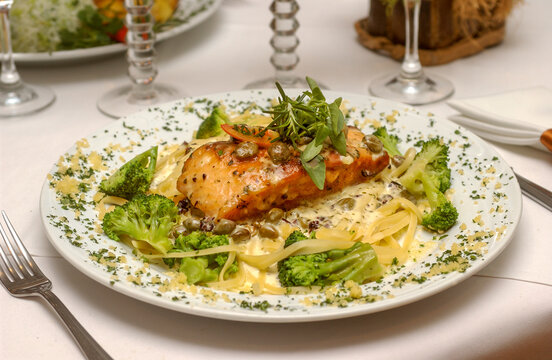 Grilled salmon with linguine, capers and broccoli. Gastronomy.