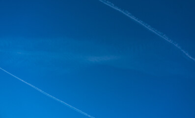 blauer Himmel mit Kondensstreifen zweier Flugzeuge