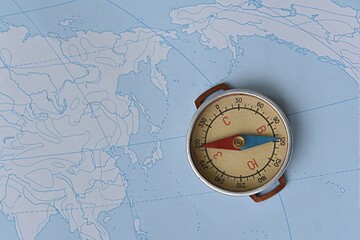 compass on the background of a contour map. journey. geography. west east concept
