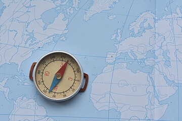 compass on the background of a contour map. journey. geography. west east concept