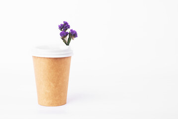 coffee cup of reusable materials with blue flowers inside on white background. zero waste concept.