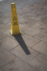 Wet floor hazard cone on a hot day