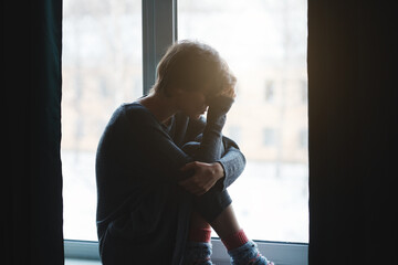 Sad stressed woman sitting alone suffering, crying, broken heart and mental health concept