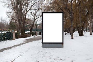 Blank billboard in snowy weather in a public park