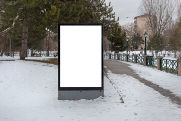Blank billboard in snowy weather in a public park