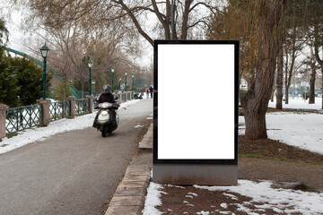 Blank billboard in snowy weather in a public park