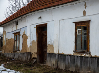 Destroyed and ruined house with red ceramic tiles, abandoned in the village