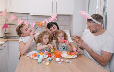 Happy Easter family paints eggs. Family values, childhood, art. A happy family celebrates the...