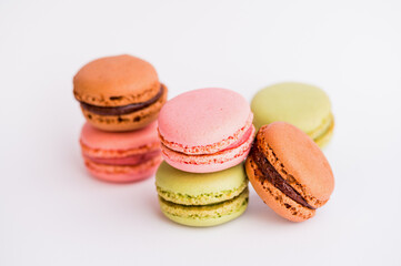 six macaroons in pink, green and brown against white background