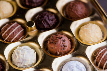 Chocolate truffles in a golden box, color macro photo