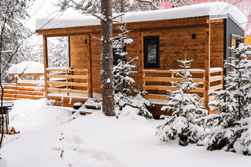 Modular house made of dark metal and light wood in winter forest. a house that takes into account...