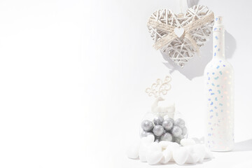 Love and winter Valentines Day white and silver creative layout made of hearts, shining balls, deer and present bottle. Aesthetic artistic. Copy space.