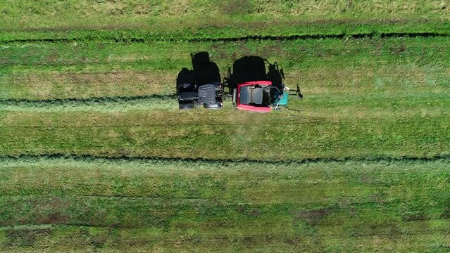 Treker mit einer Stroh Festkammerpresse bei der Strohernte auf einem gem&auml;hten Feld