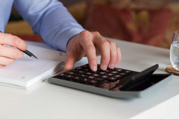 Businessman analyzing investment charts with calculator on office desk table.Close up.Financial Report Revenue Statistical Accounting Concept..