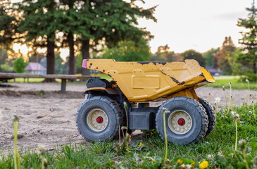 Old rusty toy truck abandoned in the park playground