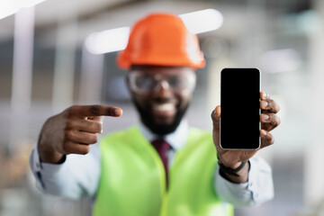 Smiling african american civil engineer showing smartphone with empty screen