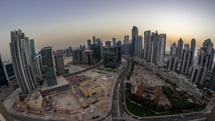 Fototapeta na wymiar Panoramic skyline of Bay Avenue with modern towers residential development in Business Bay aerial day to night timelapse, Dubai