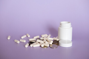 Close up white pills and capsules on purple background with copy space. Focus on foreground, soft bokeh. Pharmacy drugstore concept.