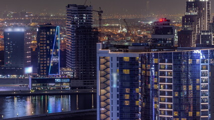Business Bay Dubai skyscrapers with water canal aerial night timelapse.