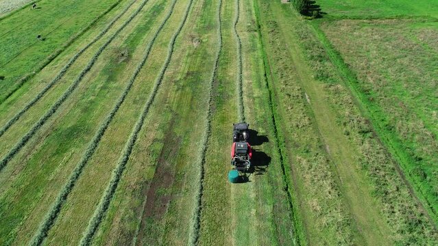 Treker mit einer Stroh Festkammerpresse bei der Strohernte auf einem gem&auml;hten Feld