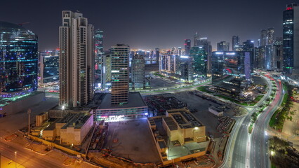 Fototapeta na wymiar Business Bay Dubai skyscrapers with water canal aerial all night timelapse.